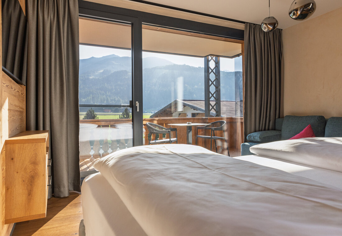 Bett in der Juniorsuite mit Blick nach draußen