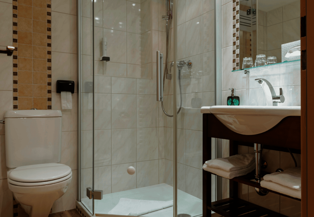 Bright bathroom with shower, toilet, washbasin and towels