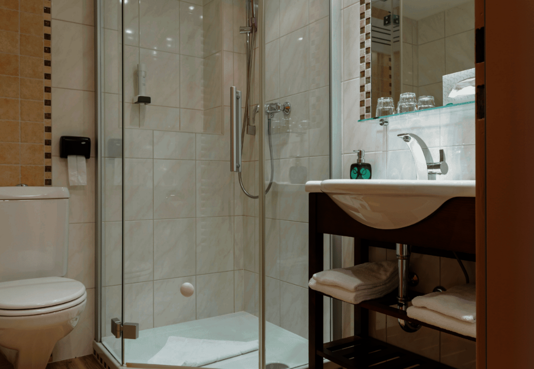 Helles Badezimmer mit Dusche, WC, Waschbecken und Handtüchern
