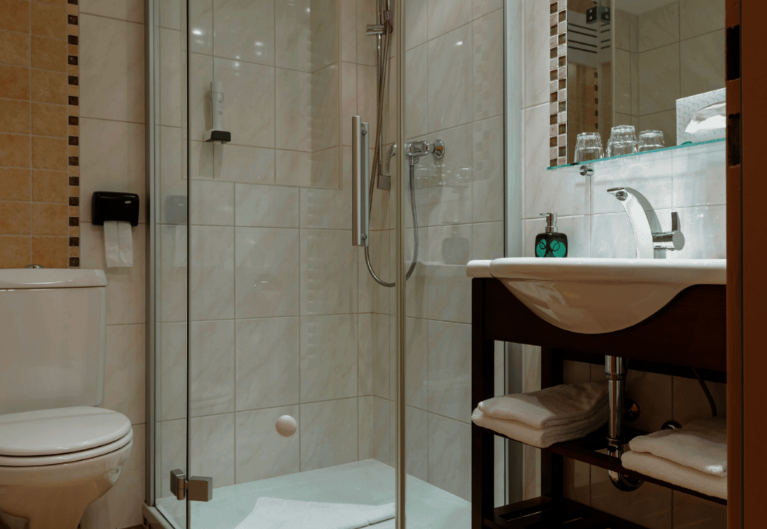 Helles Badezimmer mit Dusche, WC, Waschbecken und Handtüchern