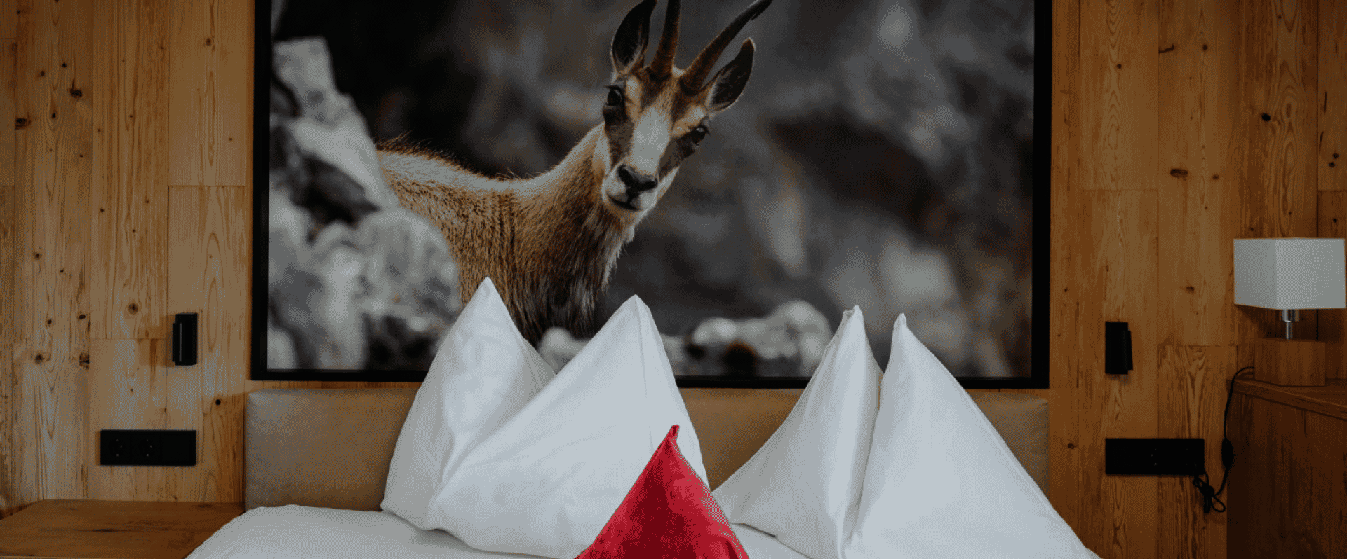 Doppelbett mit Kissen und Gamsbild