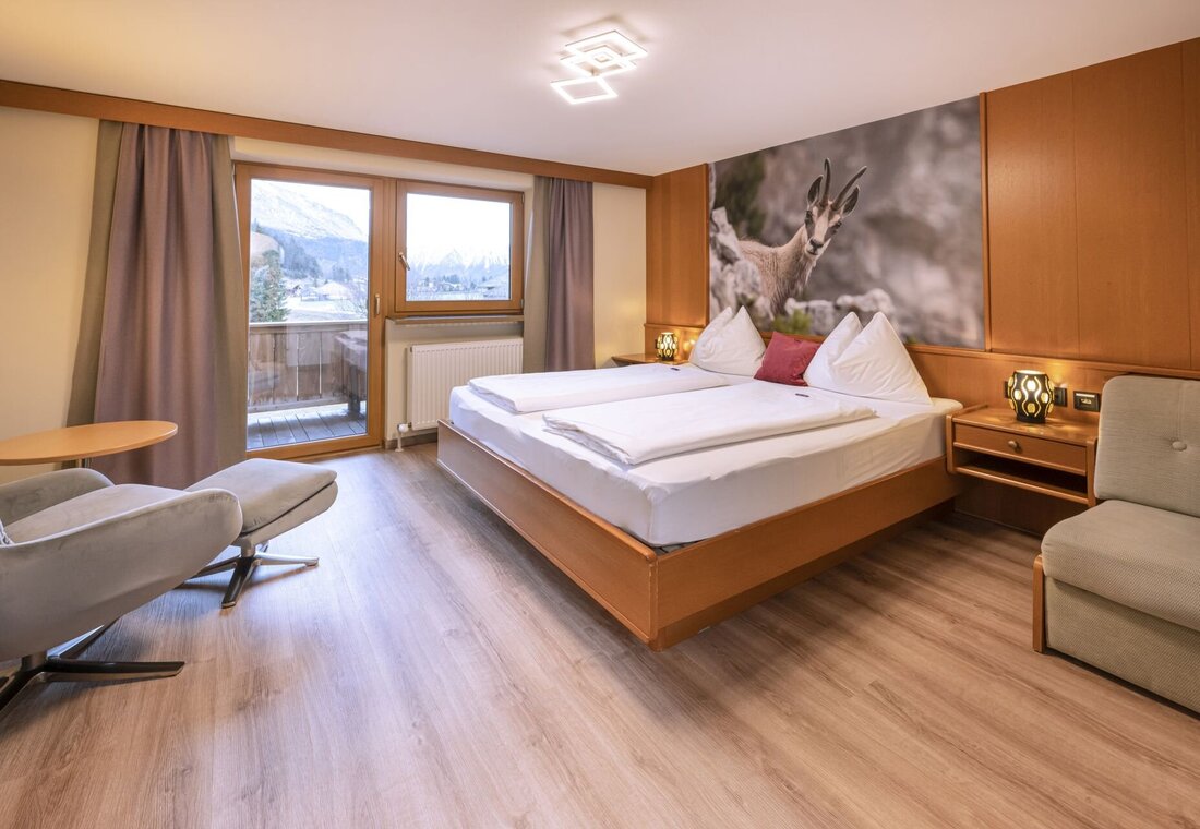 Zimmer mit Doppelbett und Sessel