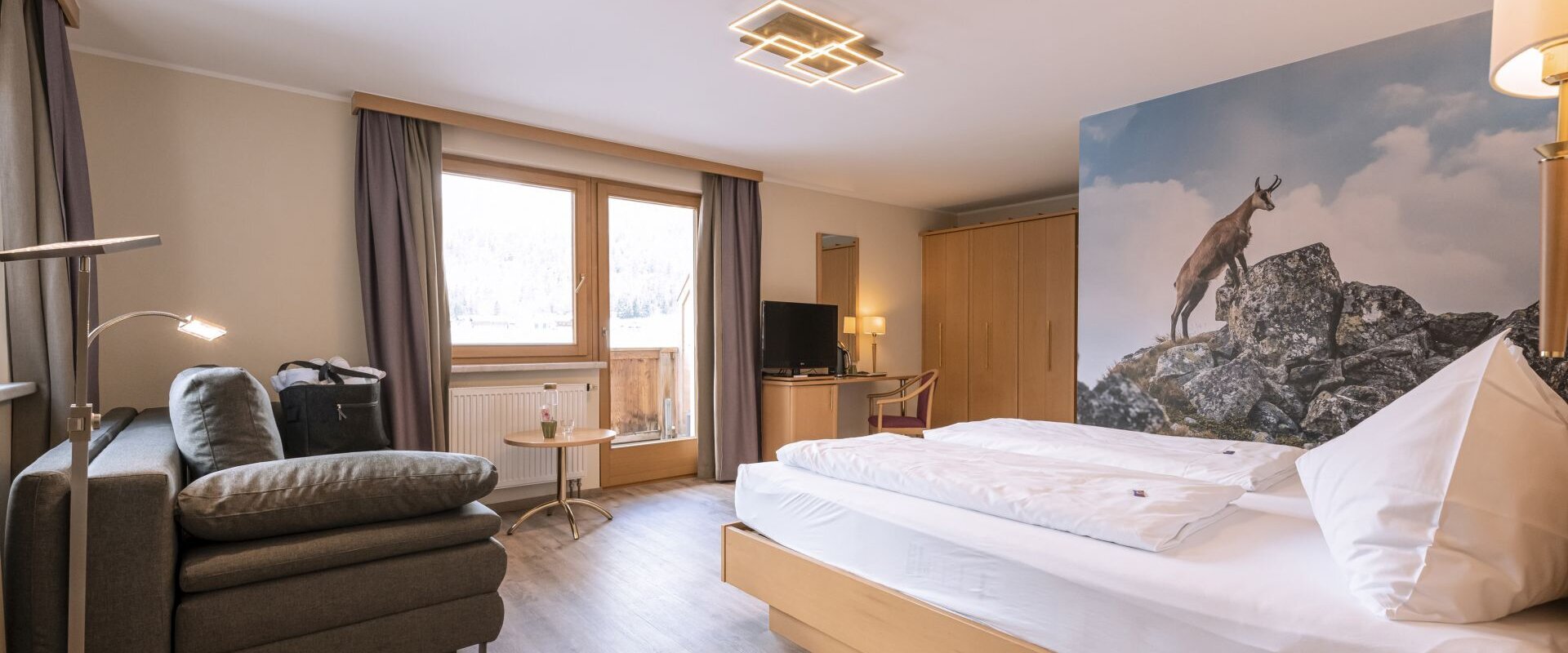 Hotelzimmer mit Doppelbett und Couch