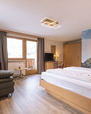 Hotelzimmer mit Doppelbett und Couch