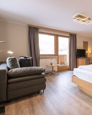 Hotelzimmer mit Doppelbett und Couch