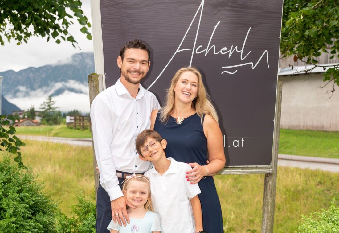 Gastgeberfamilie vor dem Acherl Schild