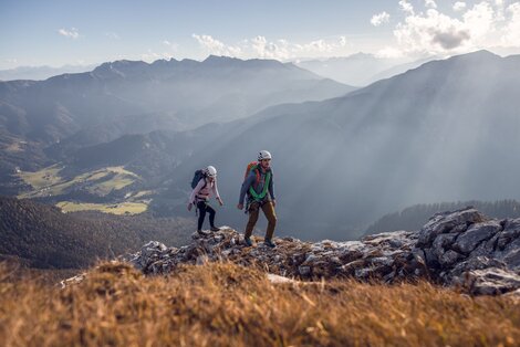 Zwei Personen am Berg mit Bergkulisse im Hintergrund