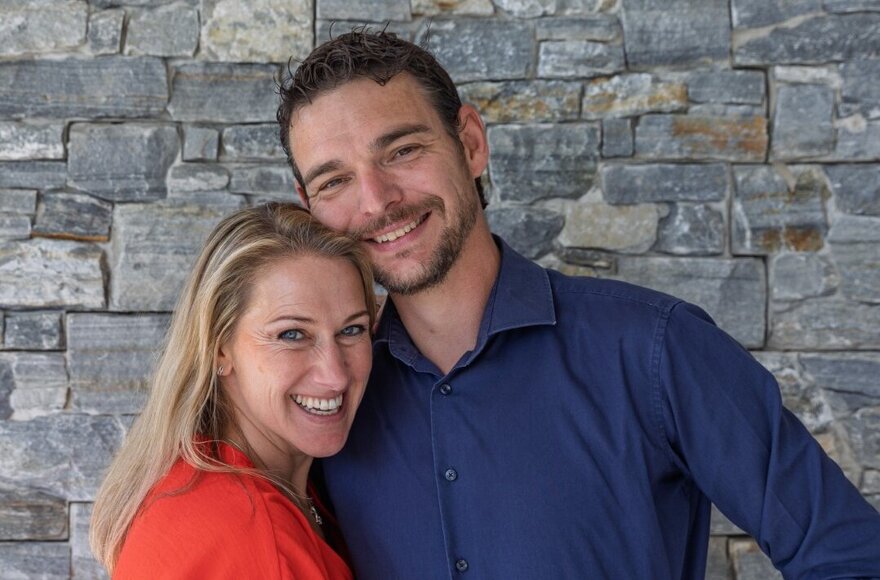 Gastgeber posieren vor einer Steinwand