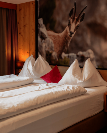 Doppelbett mit Kissen und Gamsbild
