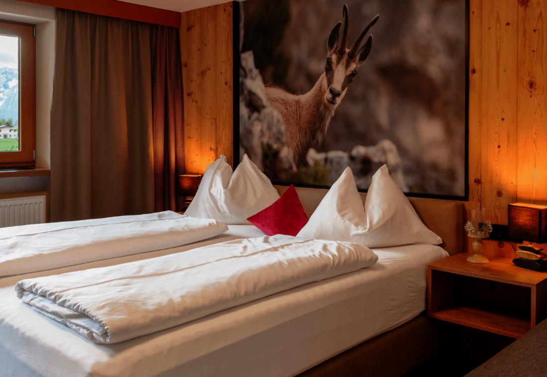 Doppelbett mit Kissen und Gamsbild