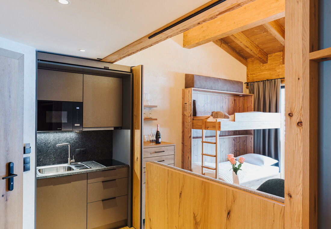 Küchenzeile mit Stockbett im Hintergrund