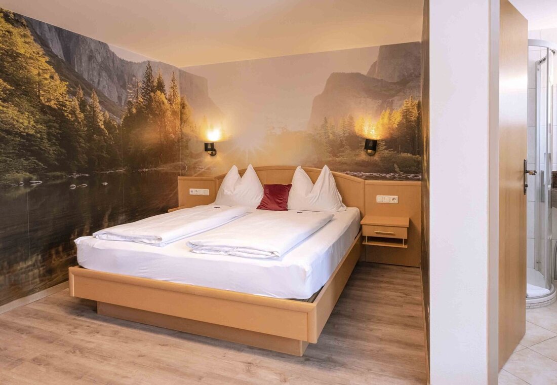 Hotelzimmer mit Doppelbett und schönem Wandbild