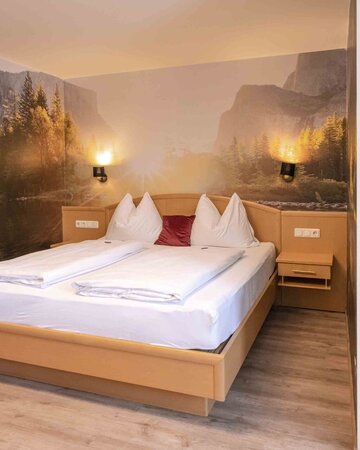 Hotelzimmer mit Doppelbett und schönem Wandbild
