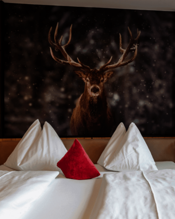 Doppelbett mit Nachttisch und Hirschbild