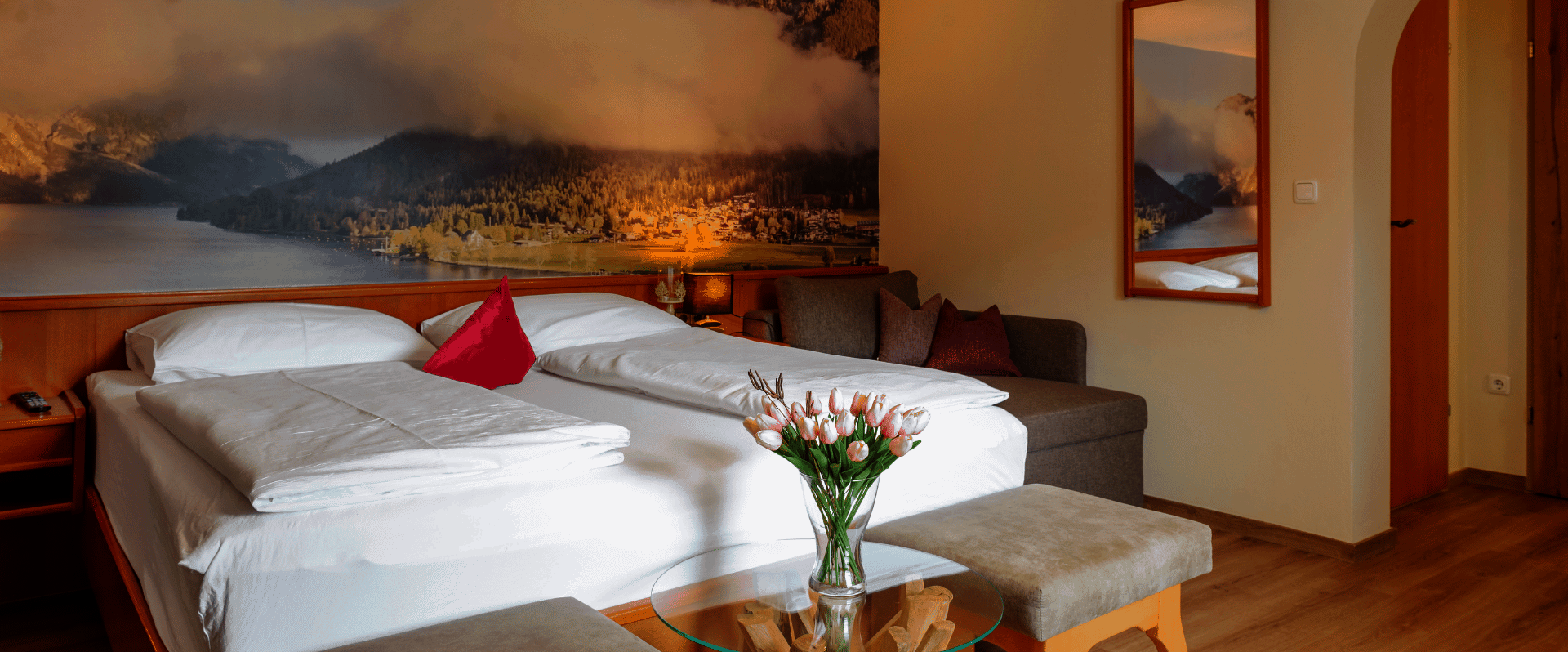 Doppelbett mit Sitzgelegenheit und Spiegel an der Wand