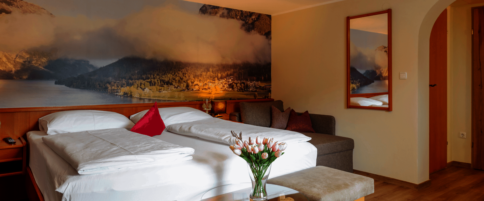 Doppelbett mit Sitzgelegenheit und Spiegel an der Wand