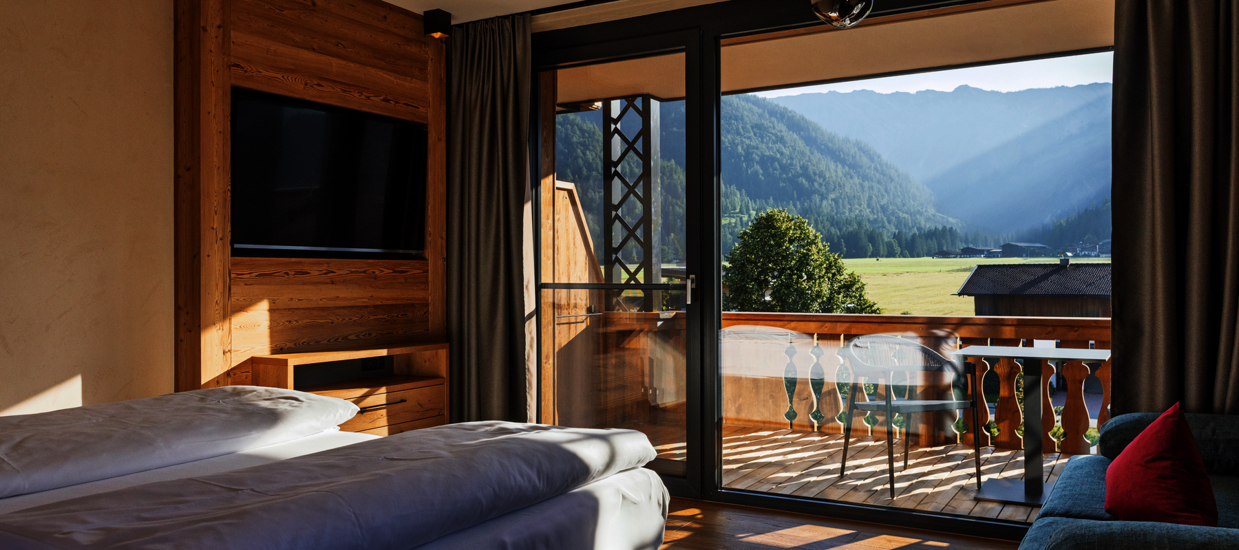 Bett mit Blick zum Balkon und Sonnenlicht