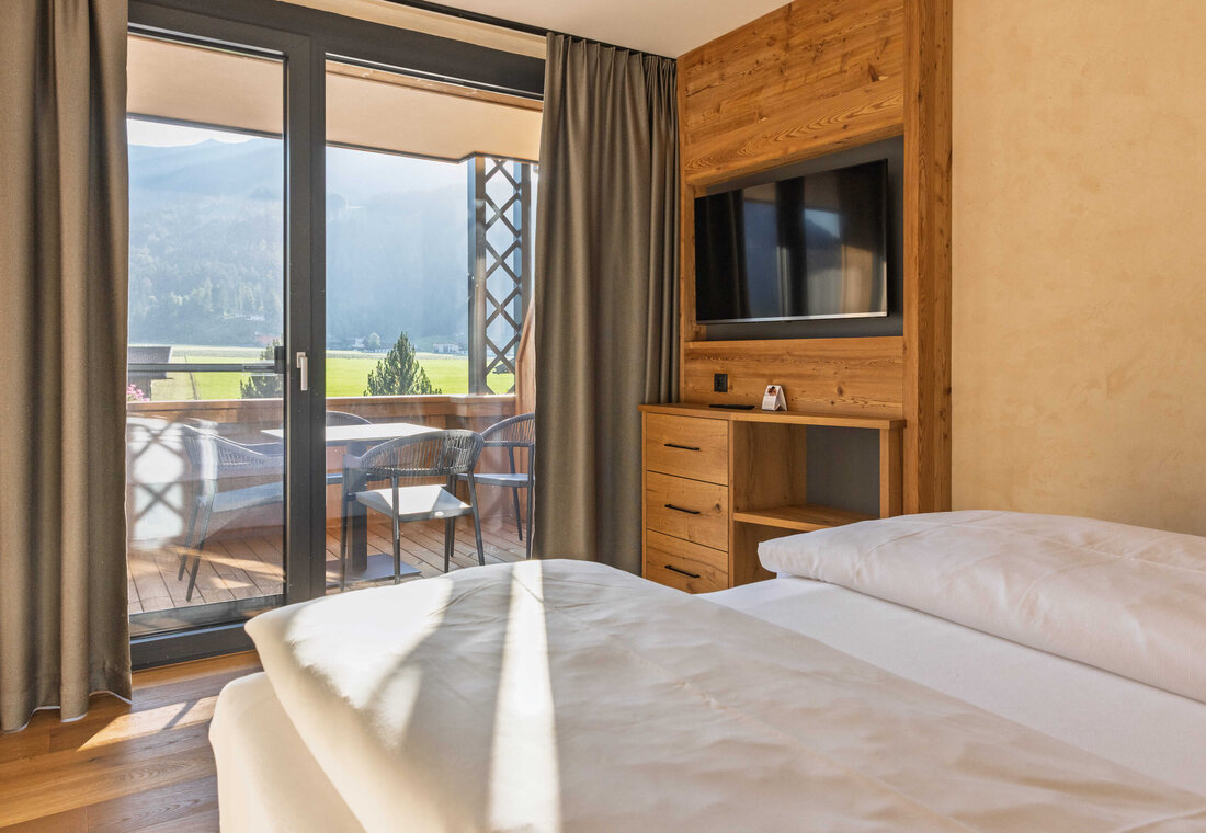 Geräumiges Doppelbett mit Ausblick auf die Berge