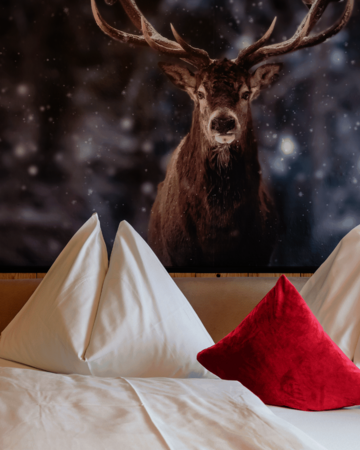 Doppelbett mit Hirschbild über dem Bett