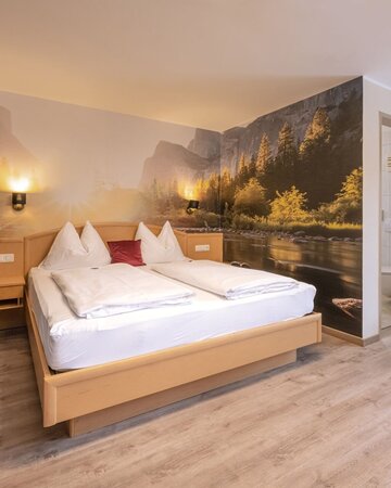 Zimmer mit Doppelbett und großem Wandbild