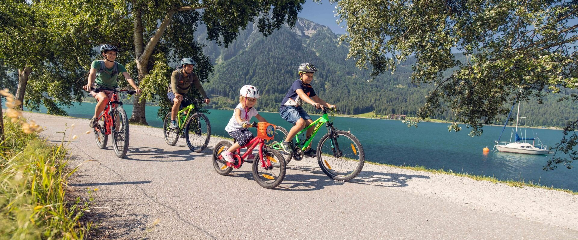Familie beim Radfahren am Ufer des Achensees
