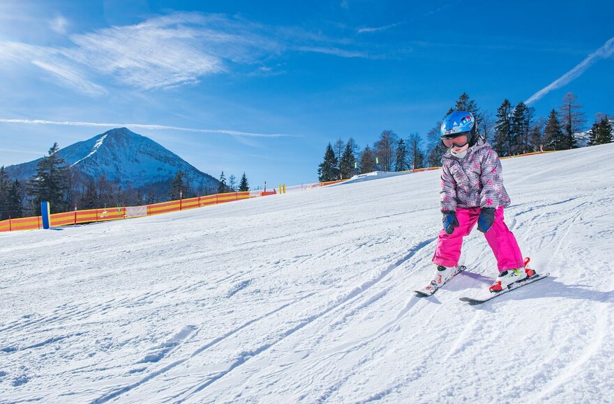 Kind beim Skifahren auf der Piste