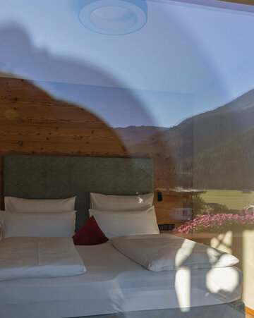 Doppelbett mit Bergspiegelung