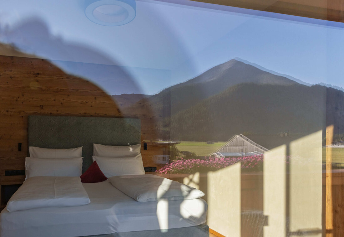 Doppelbett mit Spiegelung der Berge