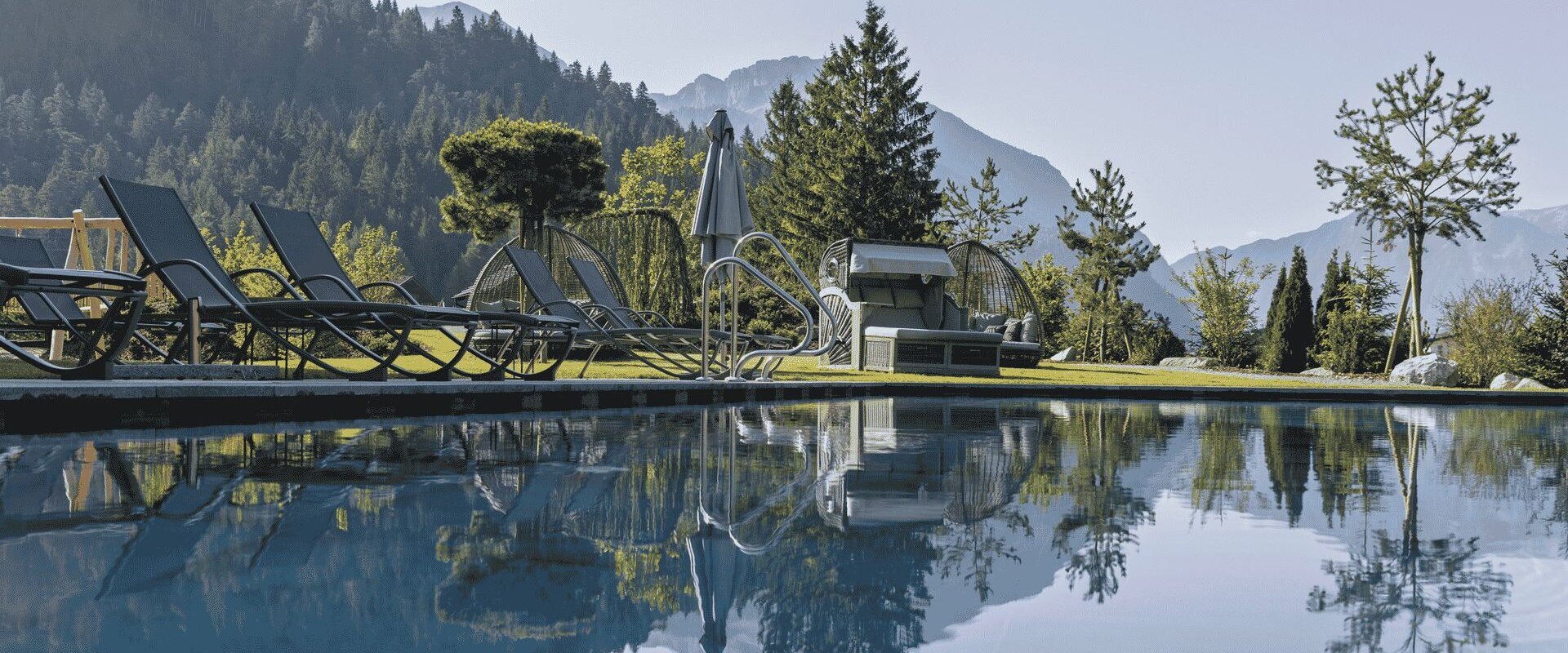 Beheizter Außenpool mit Liegen und Bergblick im Boutiquehotel Acherl