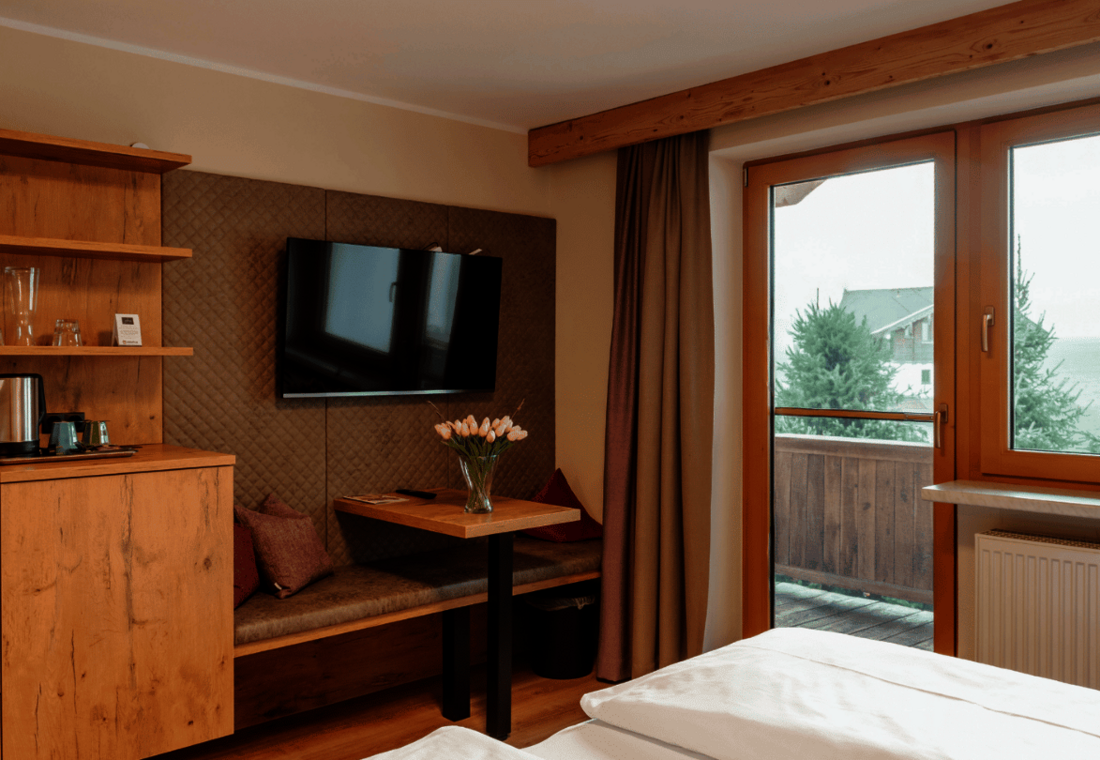 Gemütliche Sitzecke mit Tisch, TV und Teestation neben dem Balkon