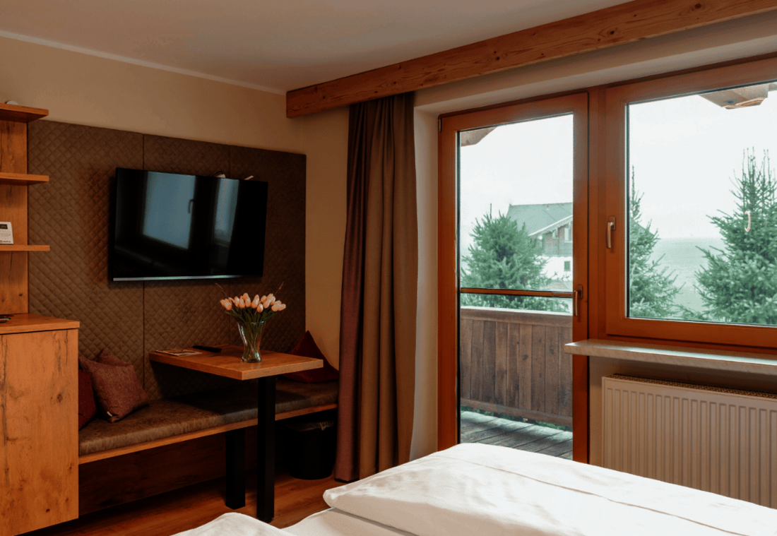 Cosy seating corner with a table, TV and tea station beside the balcony