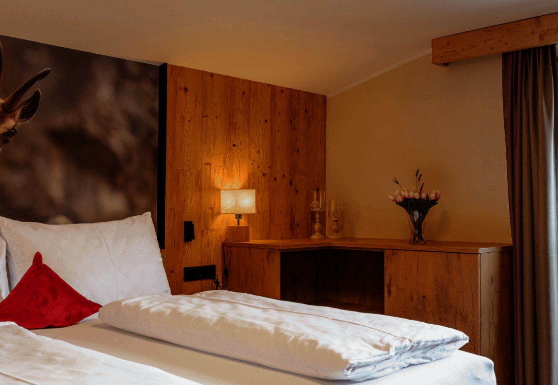 Doppelbett mit Wandbild und Schreibtisch